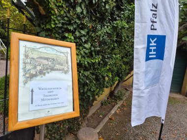Schild mit Veranstaltungstitel und Wegweiser