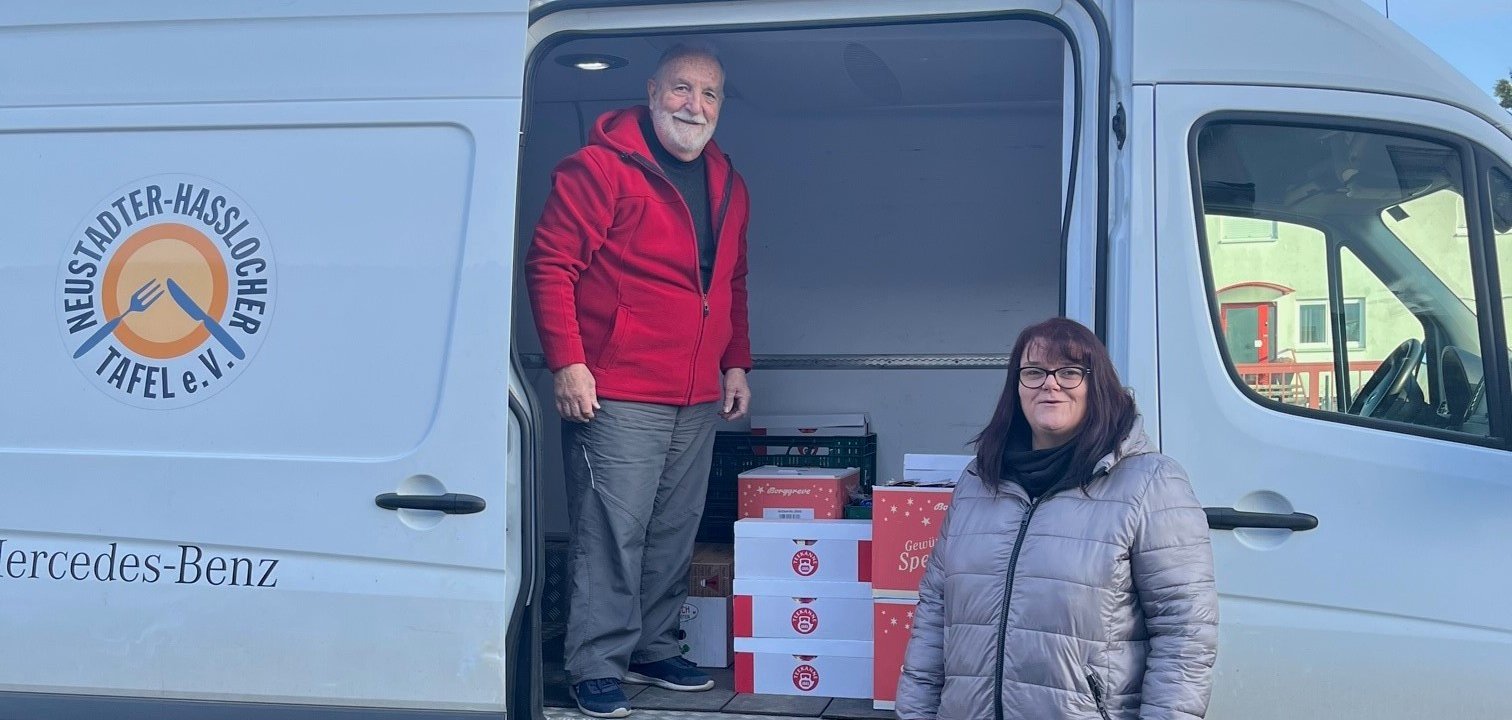 Vertreter der Tafel mit einem weißen Bus und den Waren. 