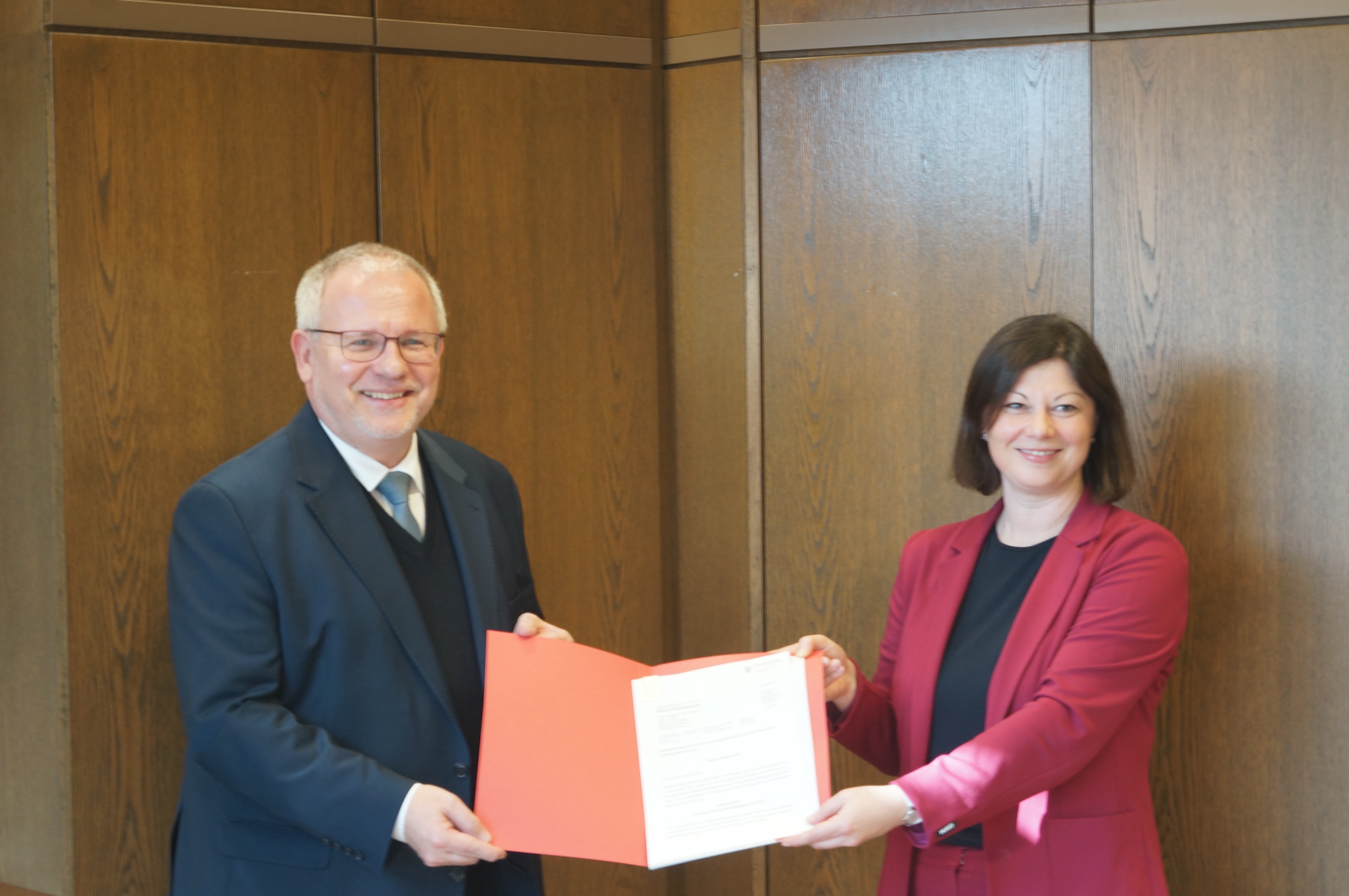 Nicole Steingaß (re) übergibt den Förderbescheid an Hans-Ulrich Ihlenfeld
