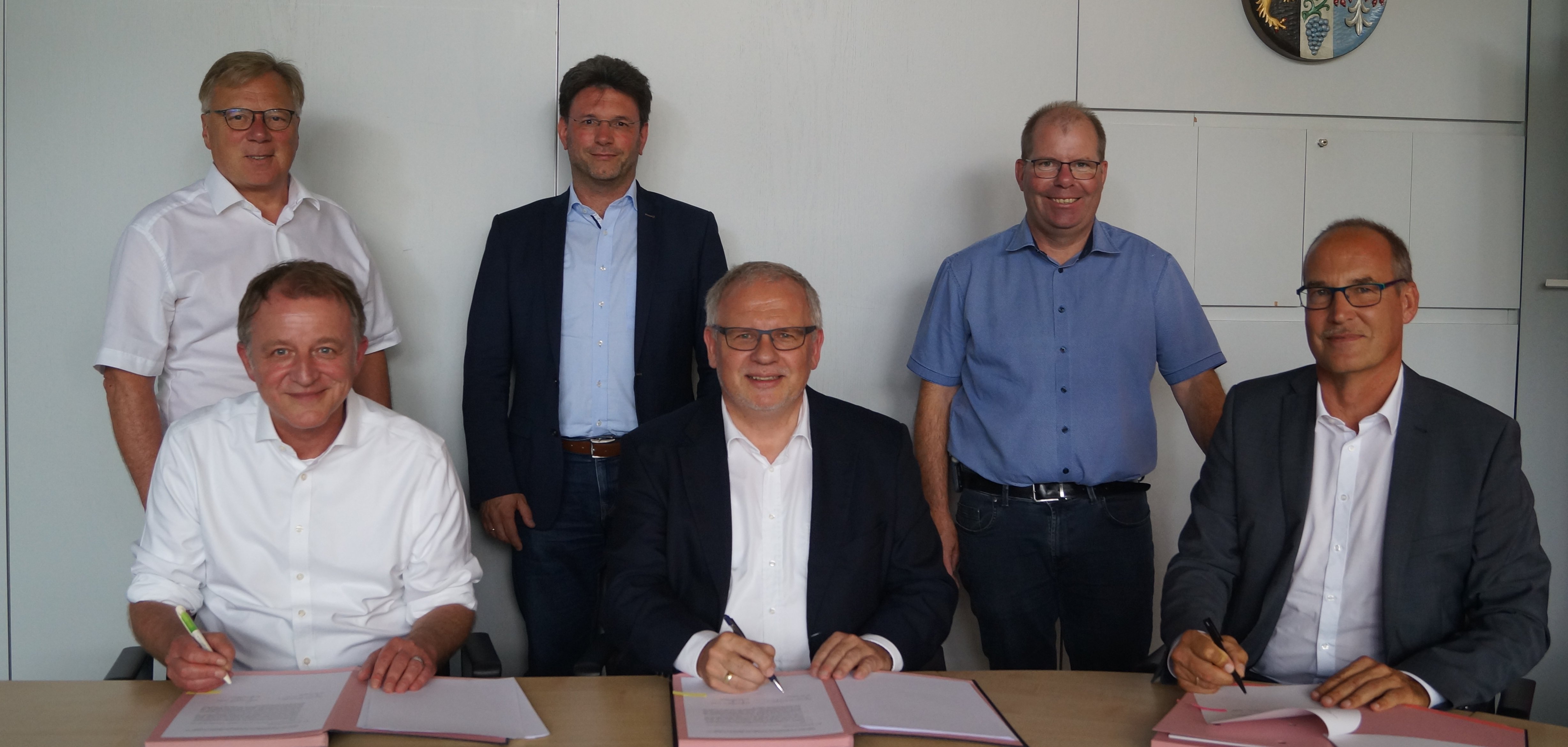 Vertragsunterzeichzung, im Hintergrund stehen die Bürgermeister