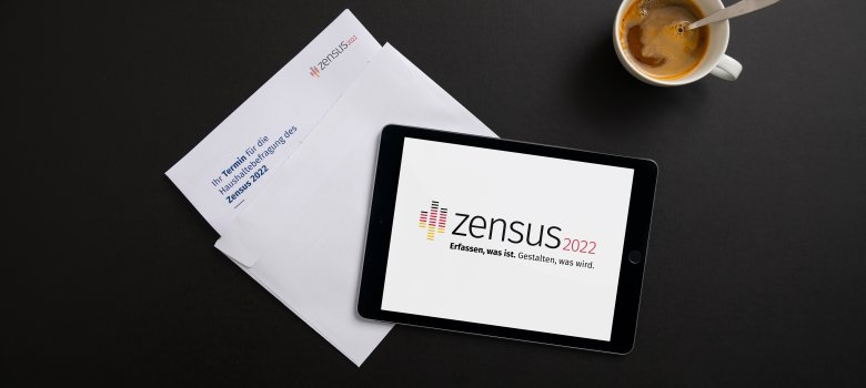 Tablet und Briefe mit Zensus-Logo liegen auf Tisch