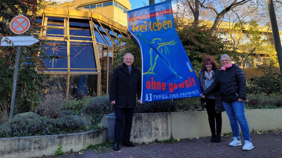 Landrat Ihlenfeld, Elke Thomas und Christina Koterba-Göbel hissen die Flagge von Terre des Femmes am Kreishaus (v.lil). 