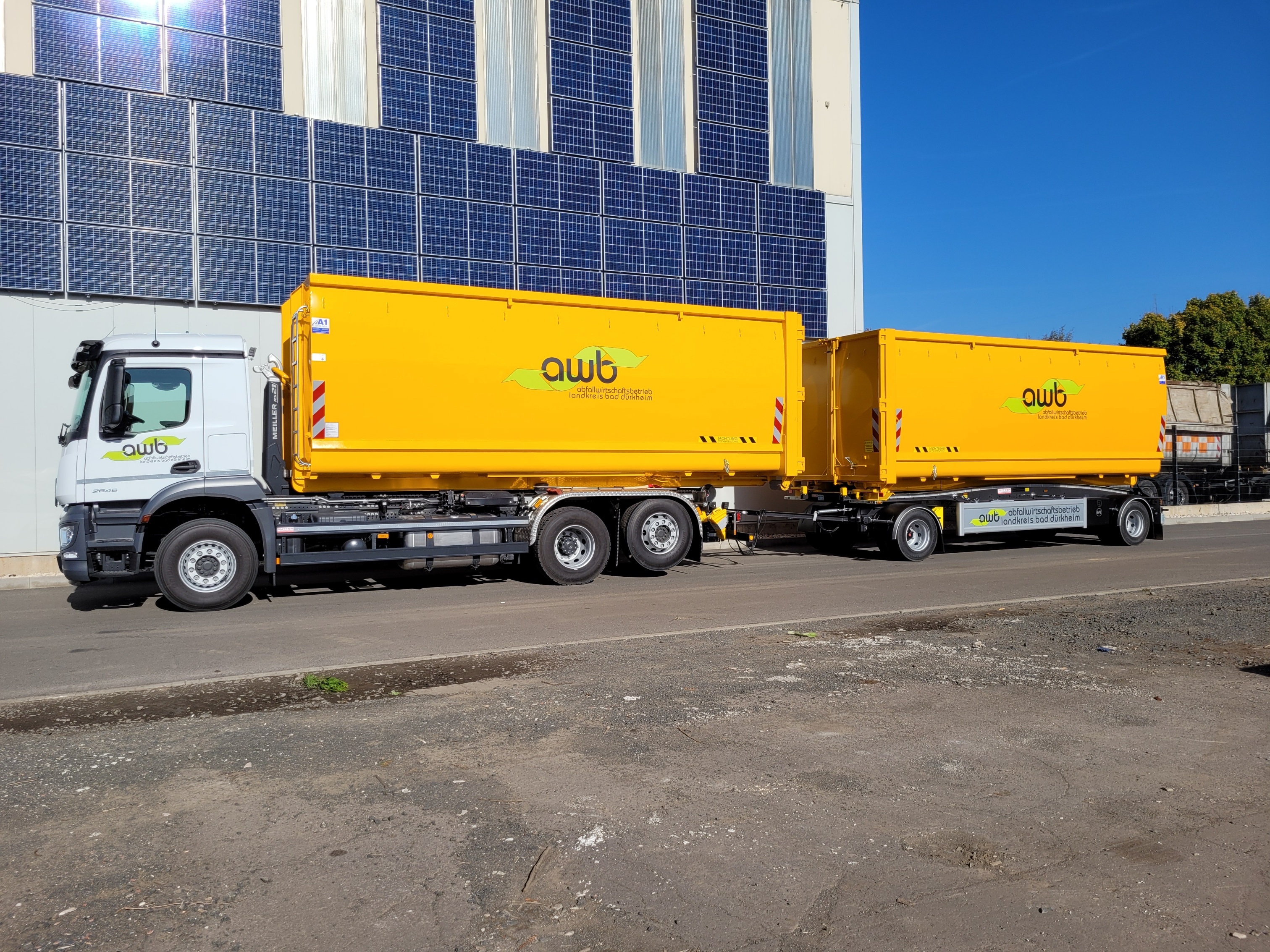 weißer LKW mit gelben Container-Anhängern