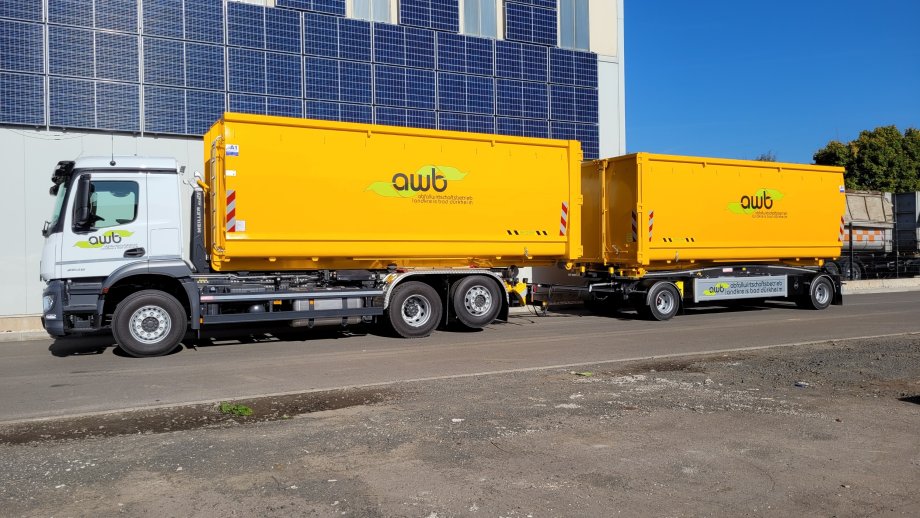 weißer LKW mit gelben Container-Anhängern