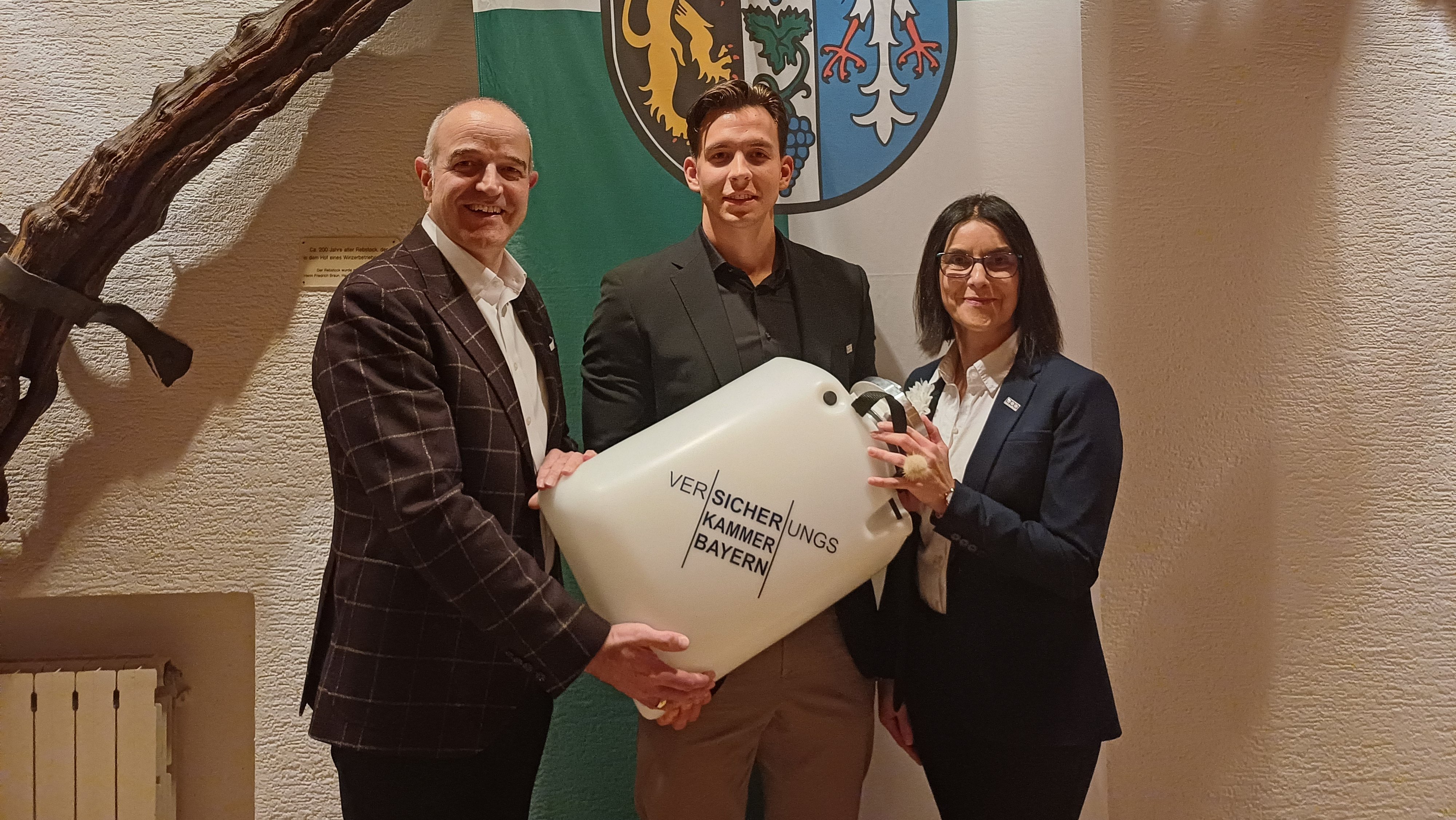 Von links: Kreisbeigeordneter Sven Hoffmann, Patrick Hosenberg, Kundenbetreuer des Kreises Bad Dürkheim, Geschäftsstelle der Versicherungskammer Bayern für den ehemaligen bayerischen Regierungsbezirk Pfalz, und Diana Kreuter-Schmitt, Direktorin der Pfälzischen Pensionsanstalt Bad Dürkheim (ppa). Sie halten einen Schwimmsauger in der Hand.