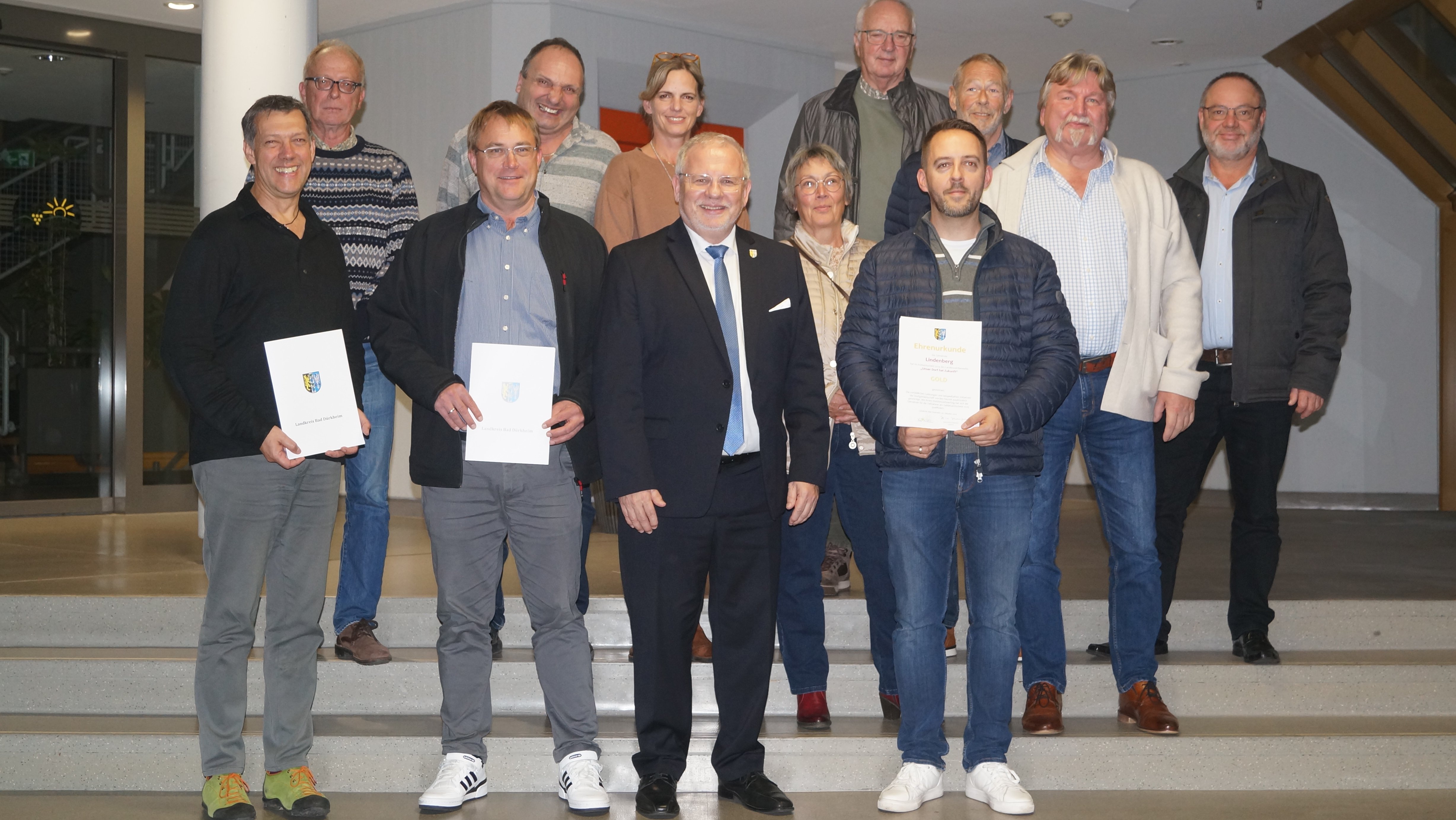 Menschen stehen hinter- und nebeneinander auf einer Treppe. In der ersten Reihe stehen von links nach rechts: Torsten Trautwein, Ortsvorsteher Leistadt, Thomas Jaworek, Ortsbürgermeister Kallstadt, Landrat Hand-Ulrich Ihlenfeld, Carsten Kus, Bürgermeister Lindenberg.
