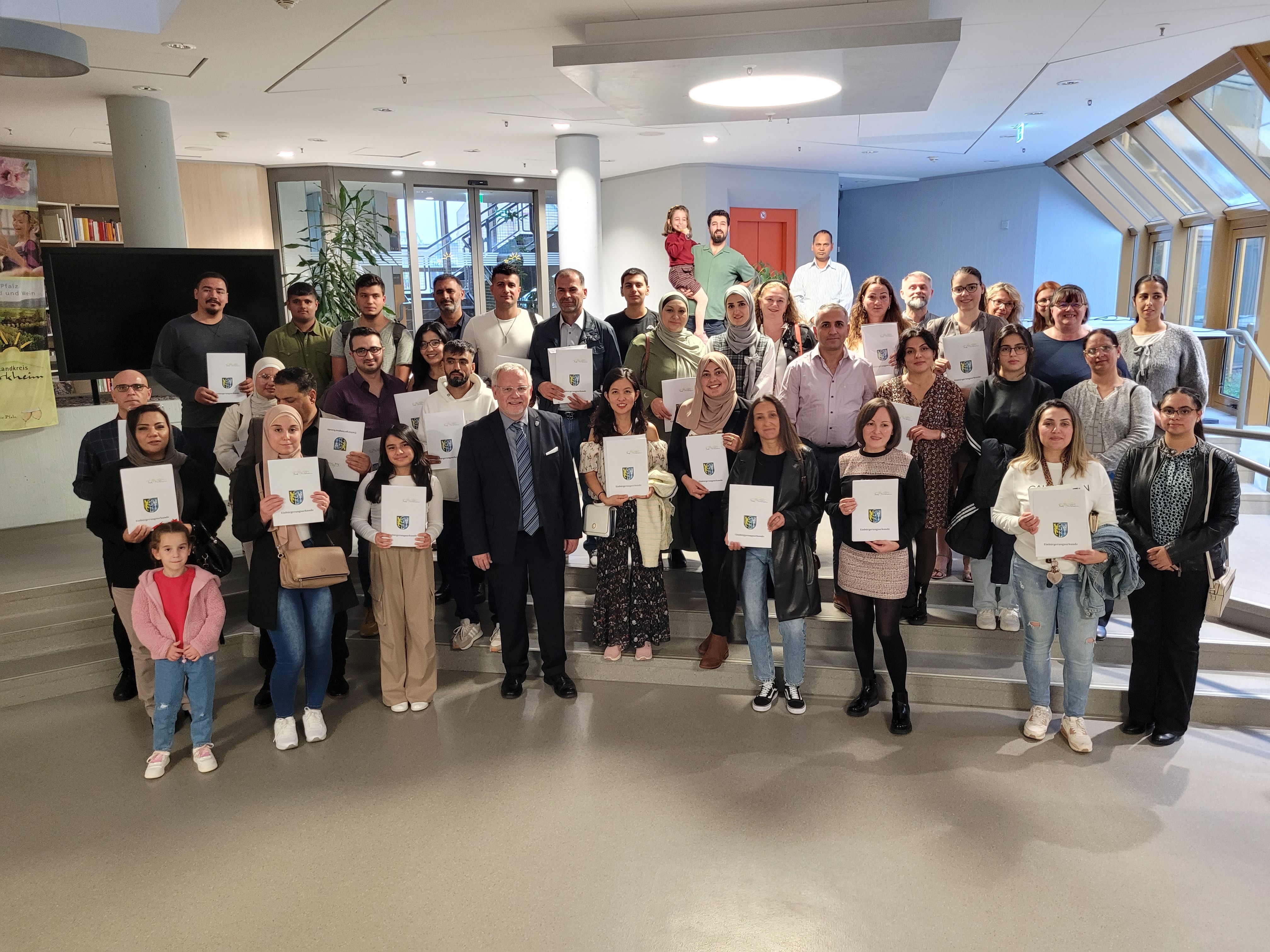 Gruppenfoto mit Menschen, die eine Urkunde in der Hand halten.
