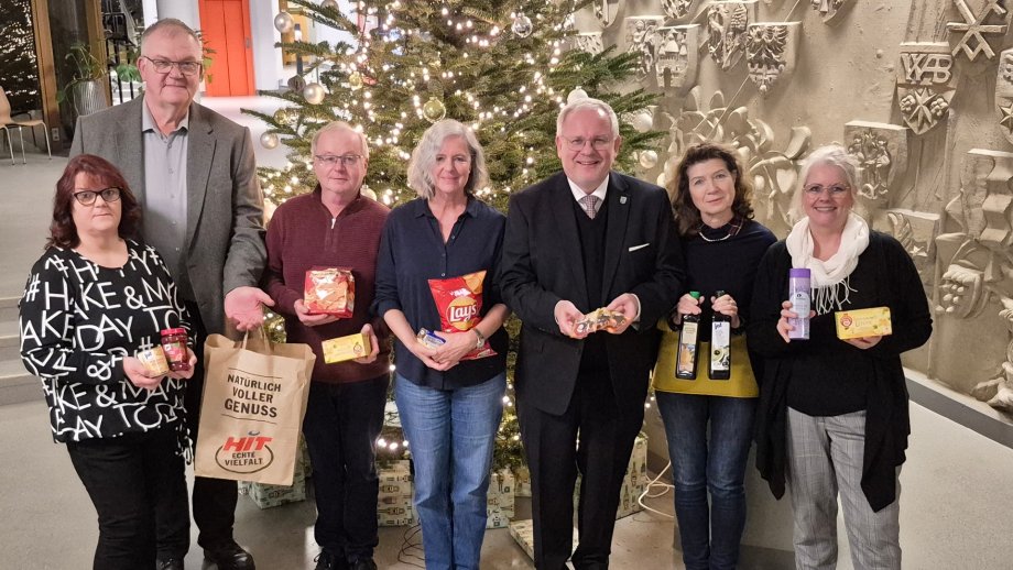 Menschengrupe vor Weihnachtsbaum.