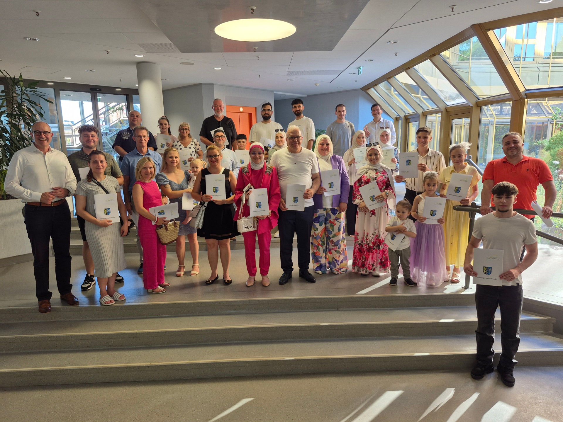 Eine Gruppe Menschen mit Urkunden in der Hand.