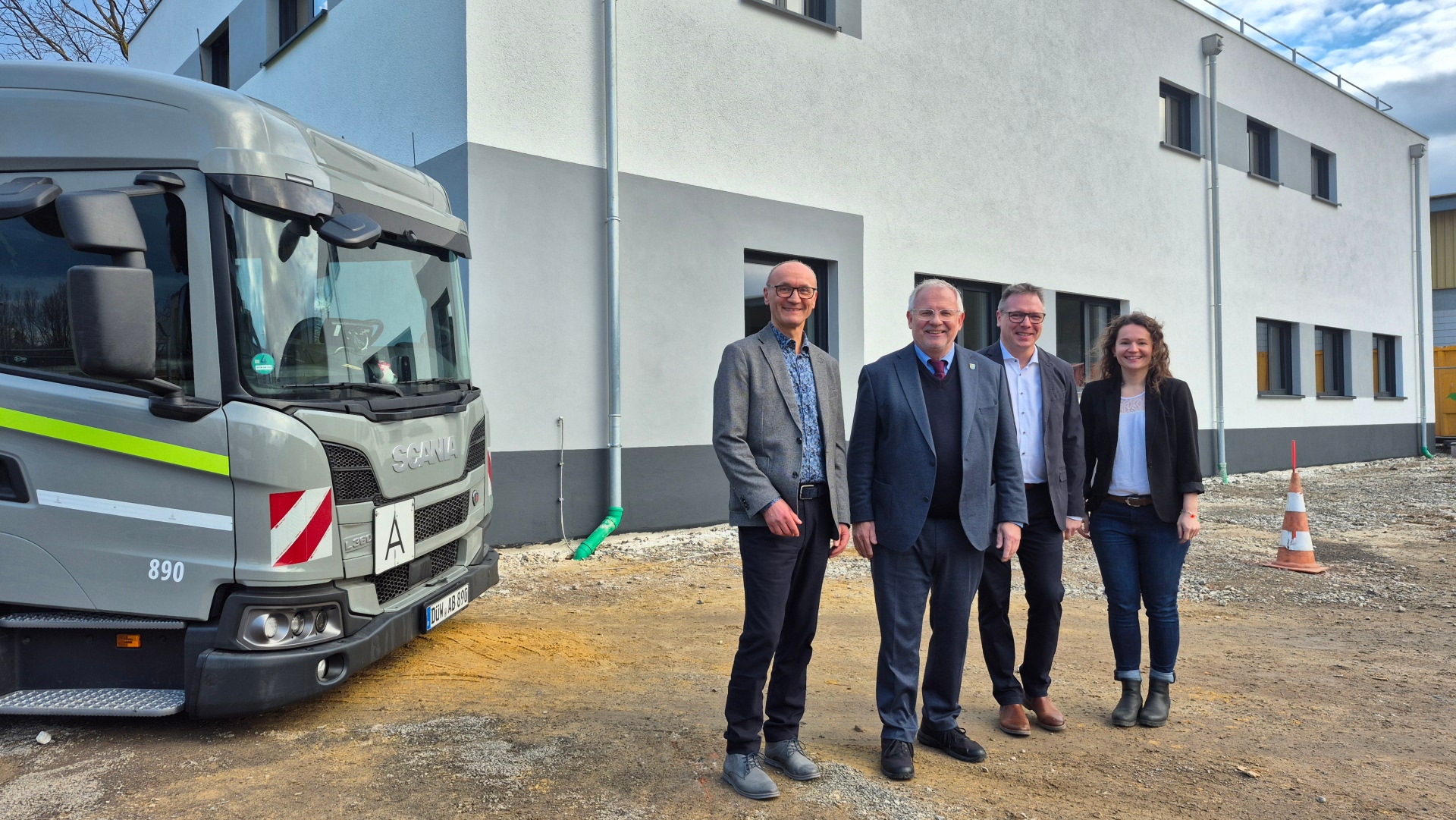 Vier Personen stehen vor einem kastenförmigen Büro-Gebäude. Es sind von links AWB-Werkleiter Klaus Pabst, Landrat Hans-Ulrich Ihlenfeld, Architekt Matthias Dichtl und die ausführende Architektin Nine Müller.