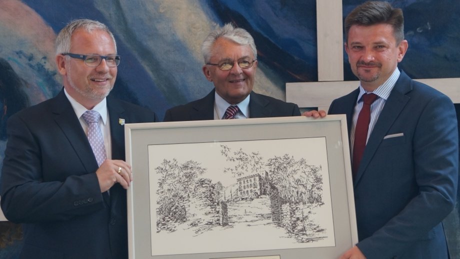 Von links: Landrat Ihlenfeld, ehemaliger Landrat Georg Kalbfuß, polnischer Landrat Piotr Pospiech mit einer Zeichnung des Hambacher Schlosses