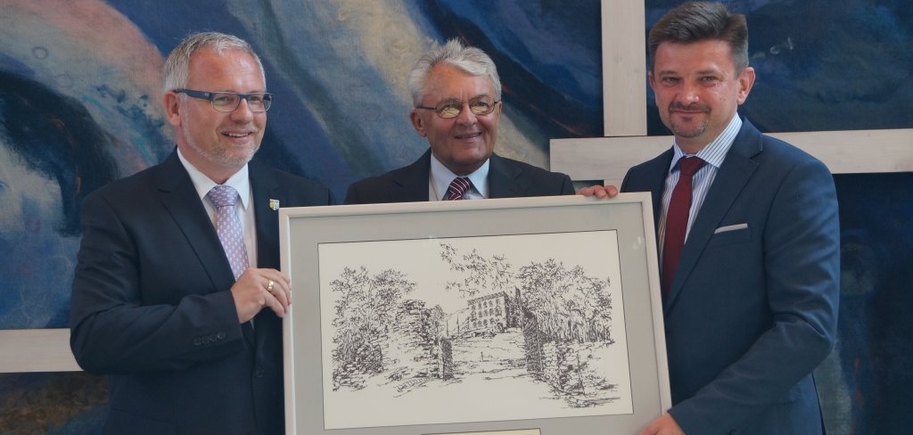 Von links: Landrat Ihlenfeld, ehemaliger Landrat Georg Kalbfuß, polnischer Landrat Piotr Pospiech mit einer Zeichnung des Hambacher Schlosses