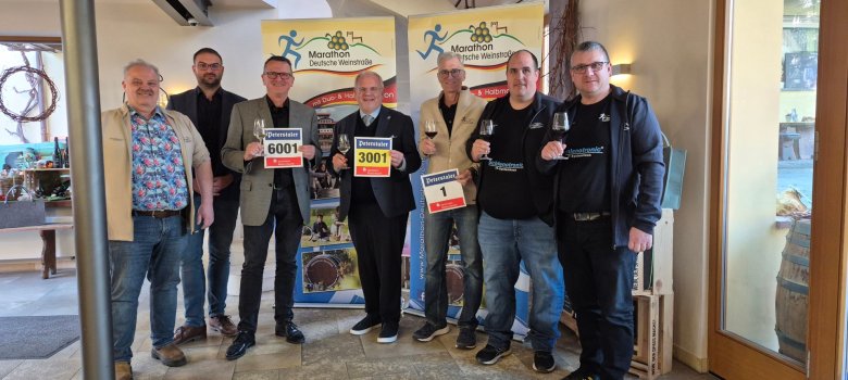 Mehrere Personen stehen nebeneinander mit einem Weinglas in der Hand. Bild von der Pressekonferenz zum 14. Marathon Deutsche Weinstraße.