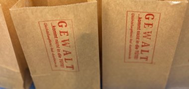 Papoertüten mit der Aufschrift "Gewalt kommt nicht in die Tüte".