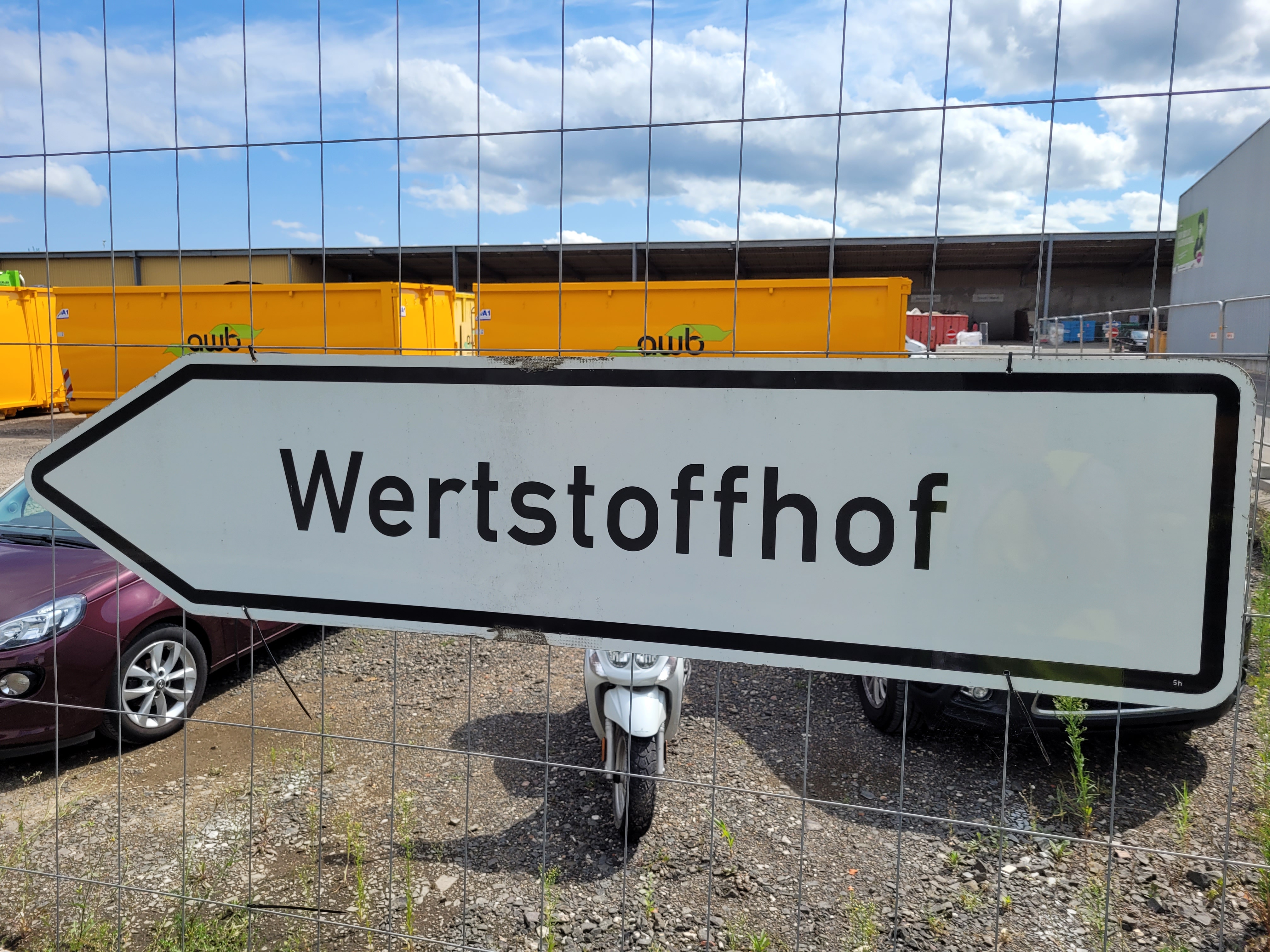 Ein Wegweiser mit der Aufschrift "Wertstoffhof".