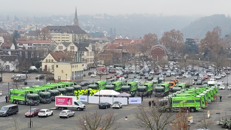 Der Wurstmarktplatz in Bad Dürkheim von oben mit 18 grün-grauen Müllautos. 