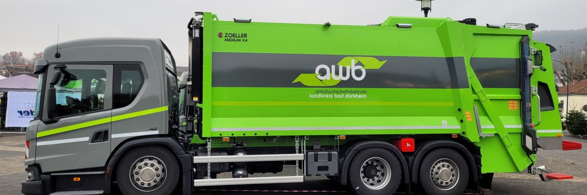 Ein Müllauto, das hellgrau und hellgrün lackiert ist m it dem Schriftzug "AWB".