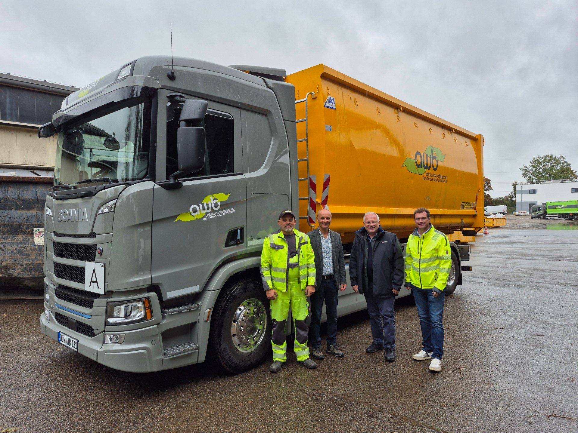 Vier Männer neben LKW.