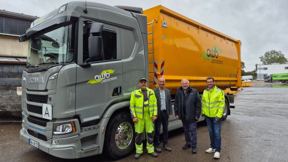 Vier Männer neben LKW.