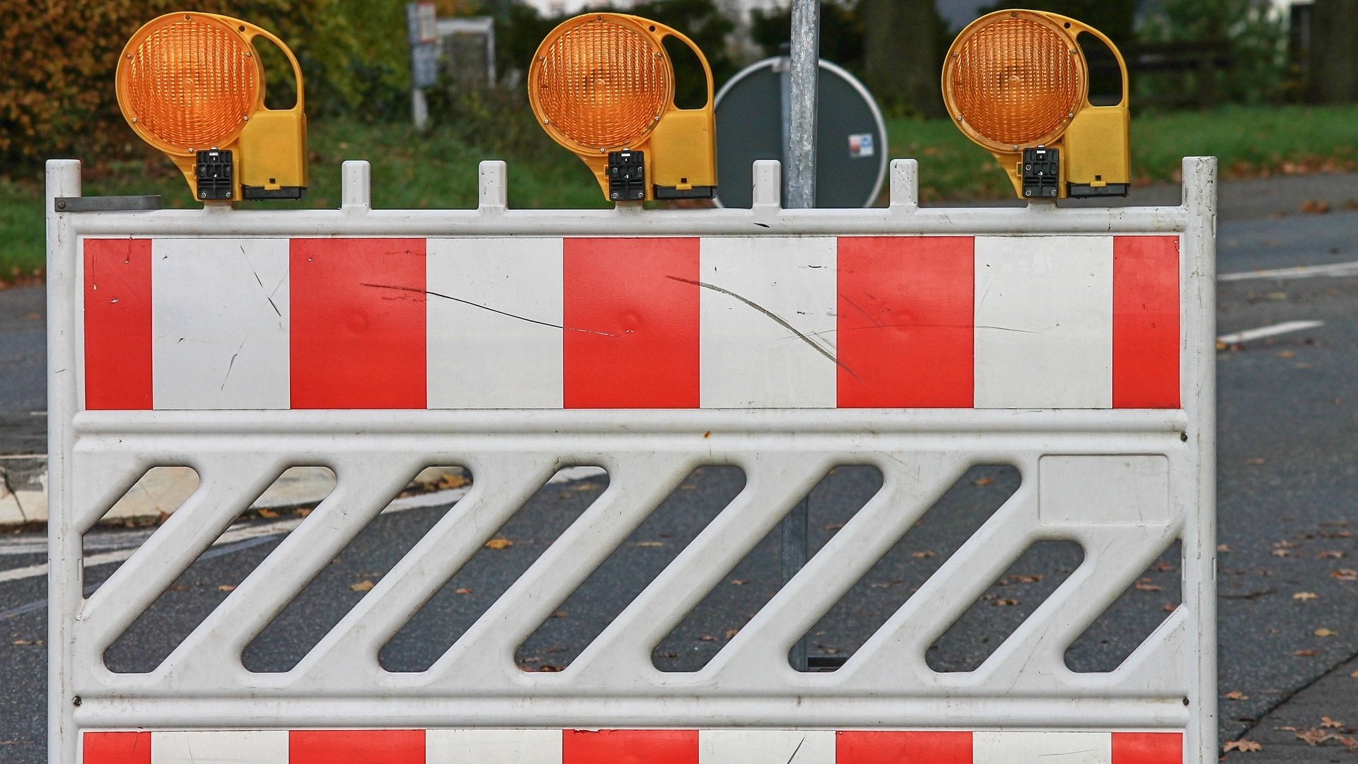 Rot-Weiße Straßenabsperrung mit gelben Warnleuchten. 