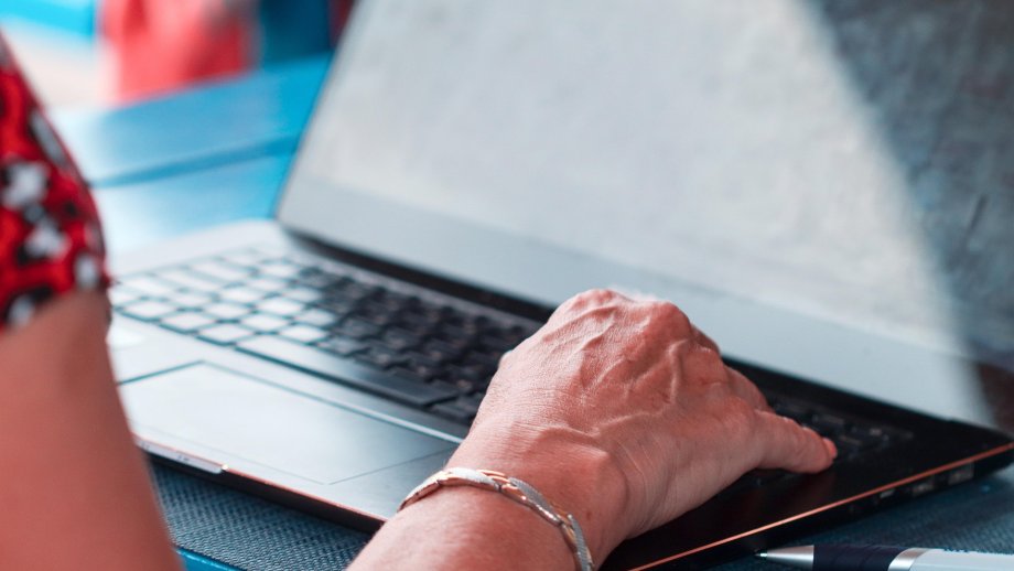 Frau legt Hand auf Laptop-Tastatur