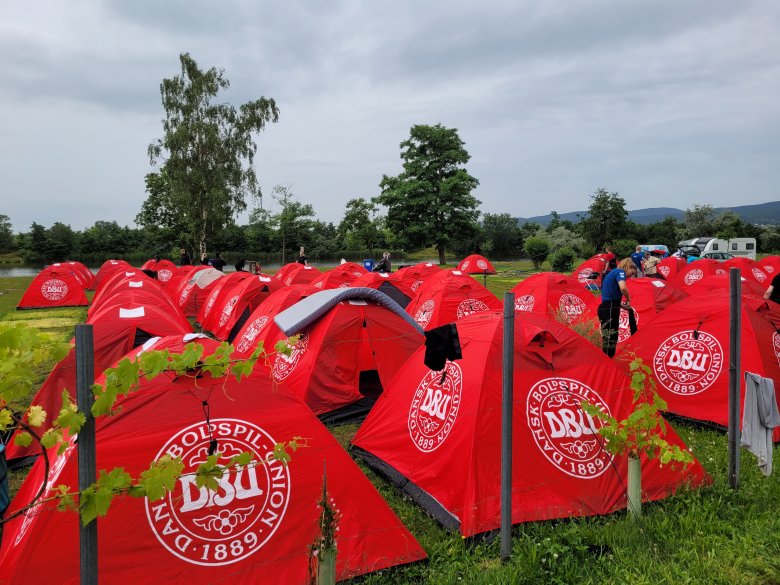 Reihenweise aufgebaute, rote Zweipersonenzelte.