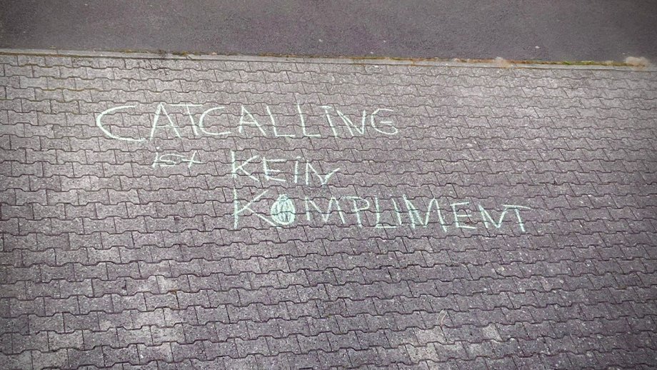 Auf eine mit Steinen gepflasterte Fläche ist "Catcalling ist kein Kompliment" geschrieben. 