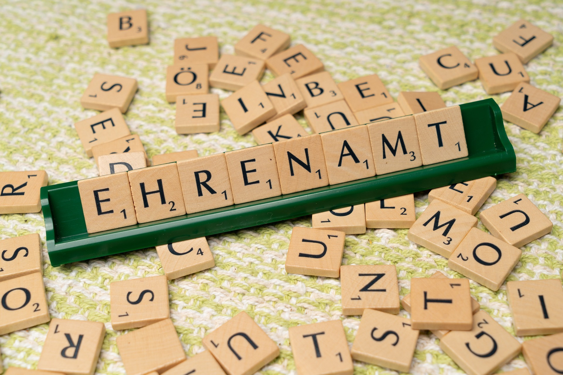 Mit Scrabble-Buchstaben ist das Wort "Ehrenamt" geschrieben.