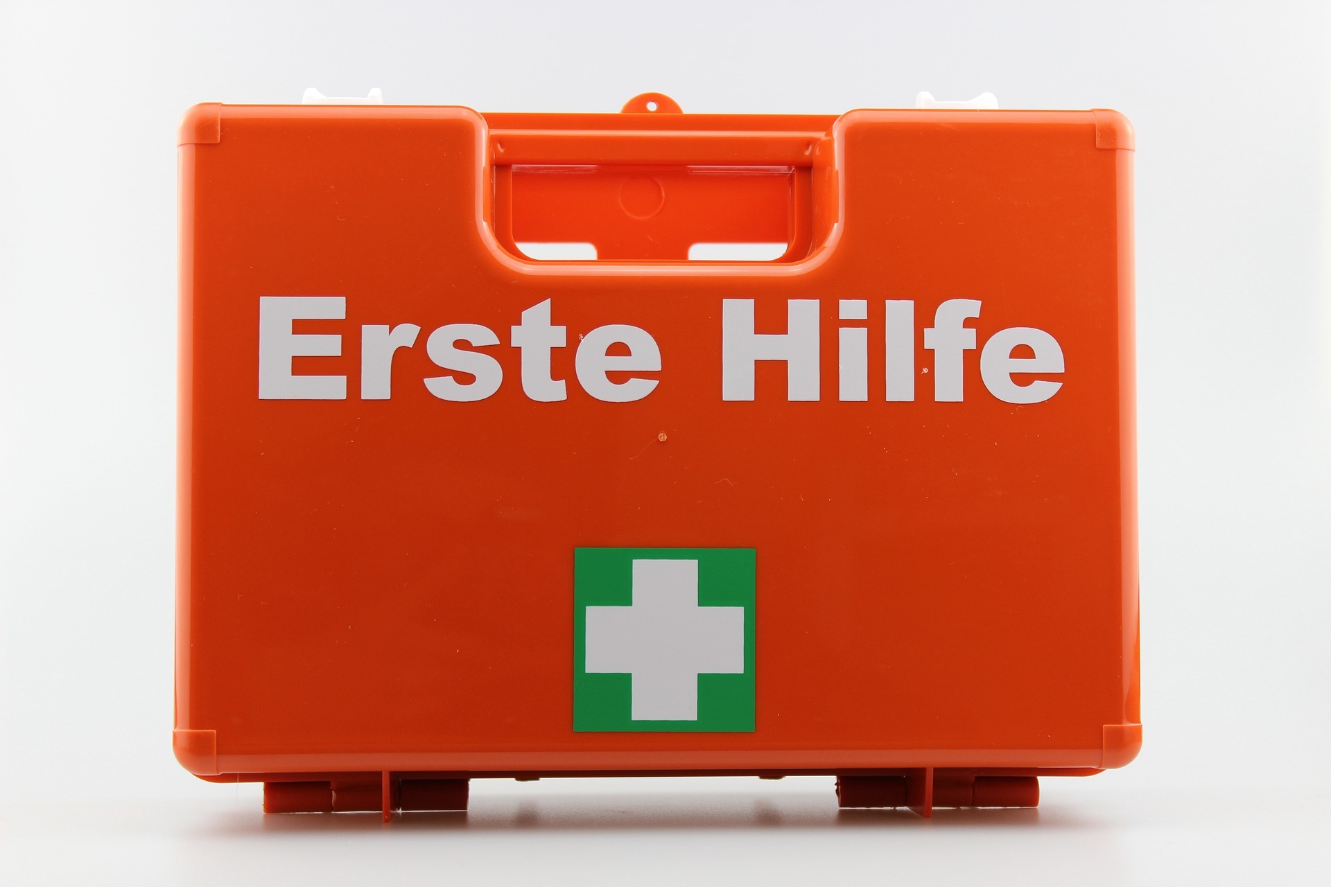 Orangefarbener, kleiner Koffer mit der Aufschrift "Erste Hilfe".