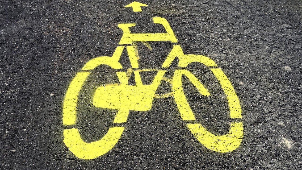 Ein gelbes Fahrrad ist auf Asphalt gesprüht.