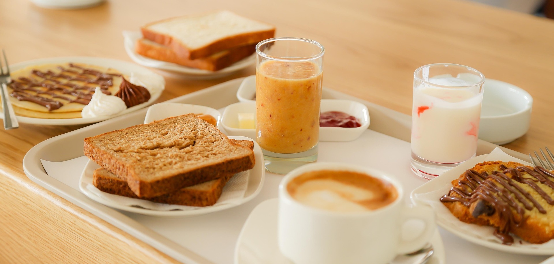 Frühstück mit Toast, Pfannkuchen, Kaffee, Saft auf Tisch