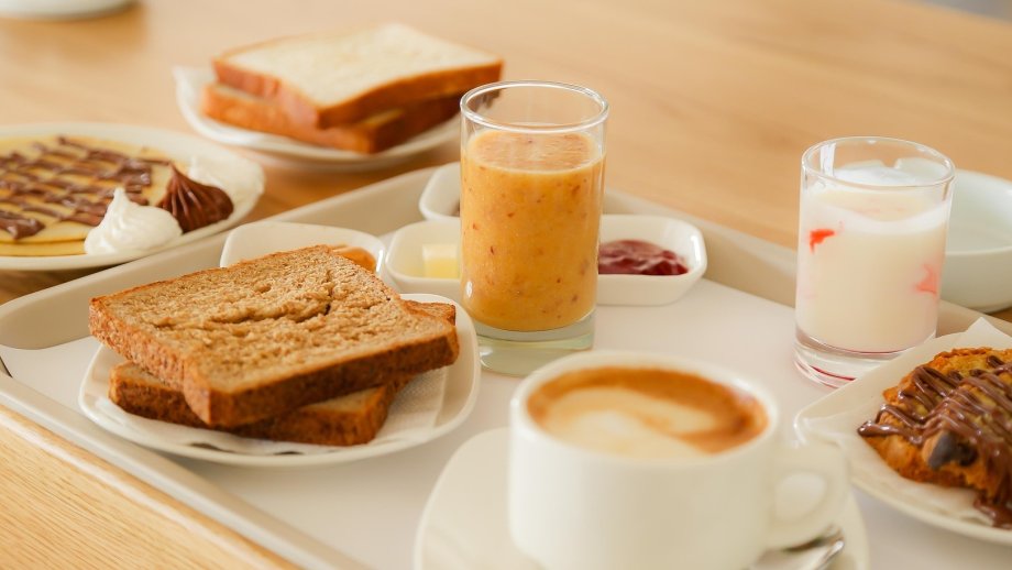 Frühstück mit Toast, Pfannkuchen, Kaffee, Saft auf Tisch