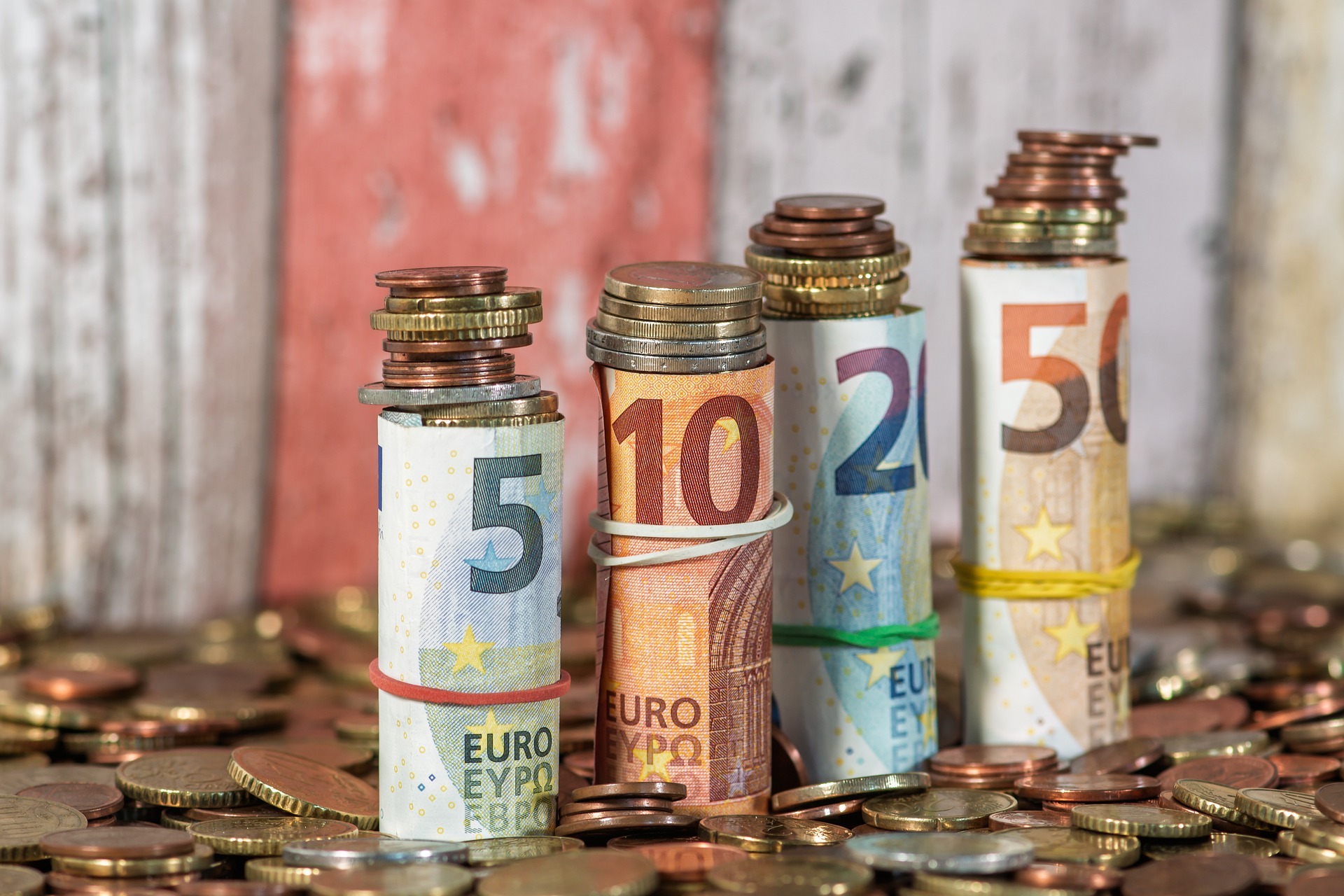 Münzen und zusammengerollte Geldscheine