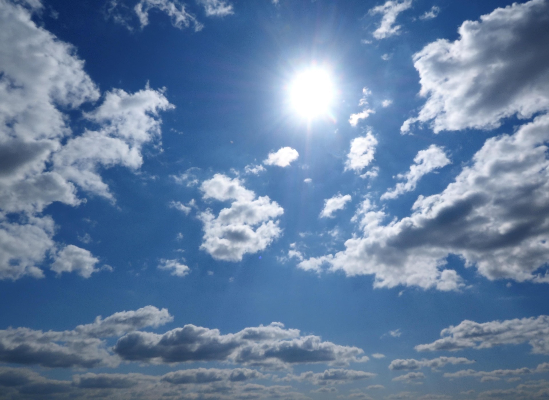 Sonne an blauem Himmel mit einigen Wolken
