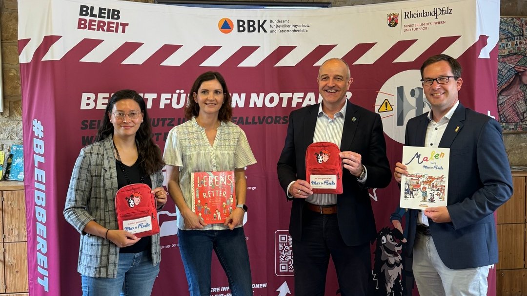 Vier Menschen vor einer Informationswand.