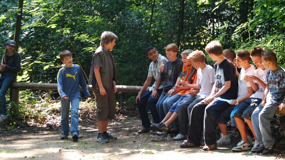 Mehrere Kinder unterhalten sich im Wald