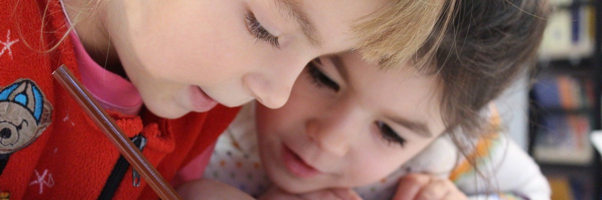 Zwei Mädchen schreiben in ein Heft