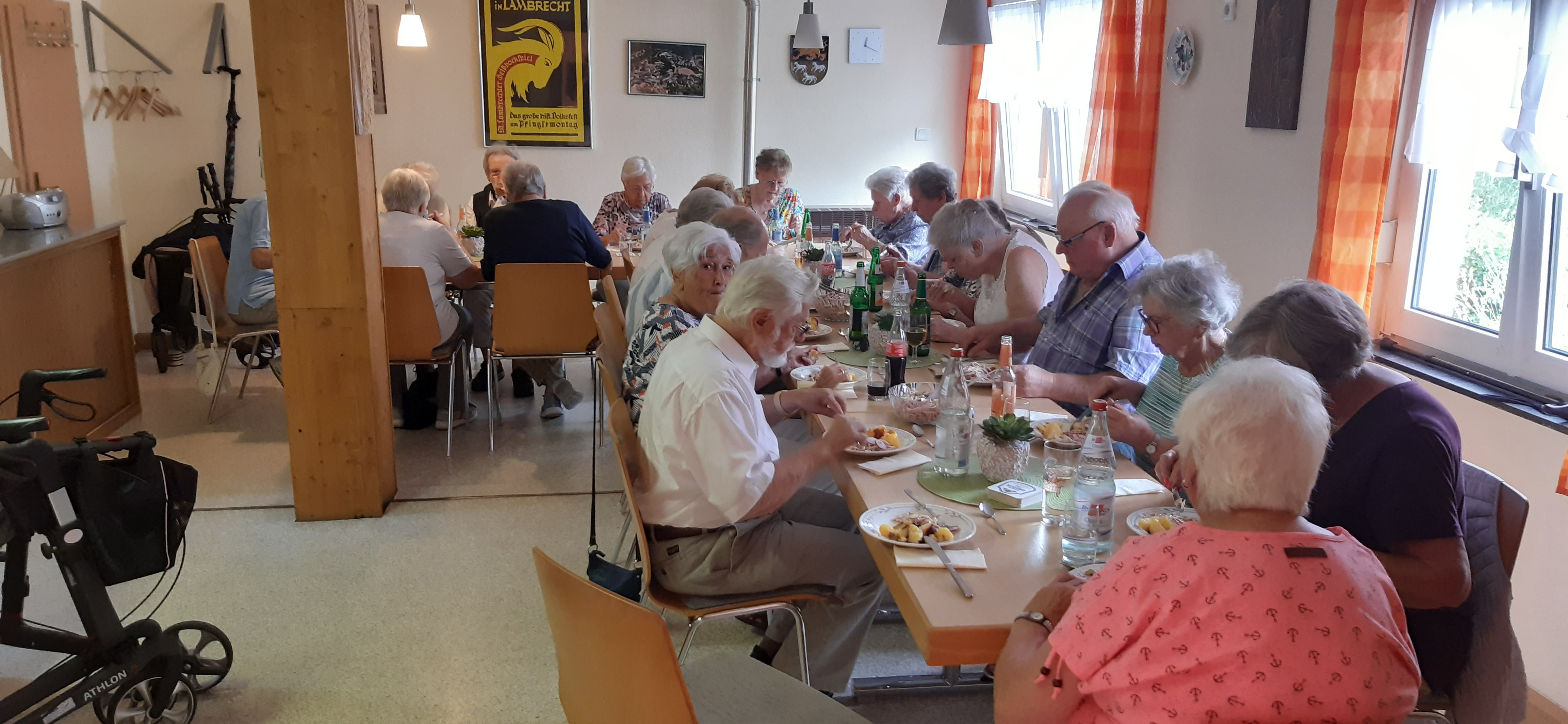 Seniorinnen und Senioren sitzen zusammen beim Essen. 