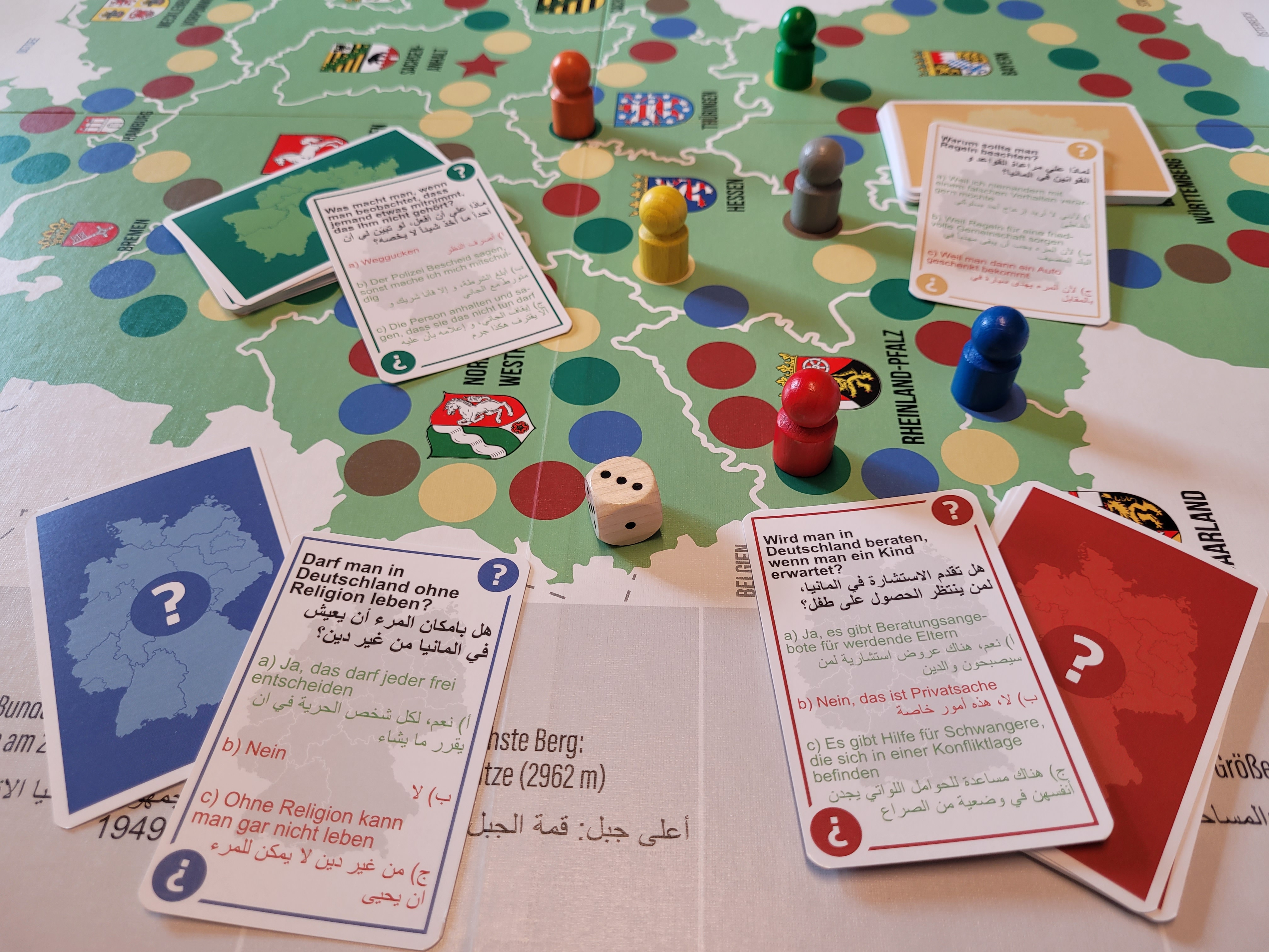 Das Spielmaterial von "Leben in Deutschland" mit Spielplan, Spielfiguren und Karten.