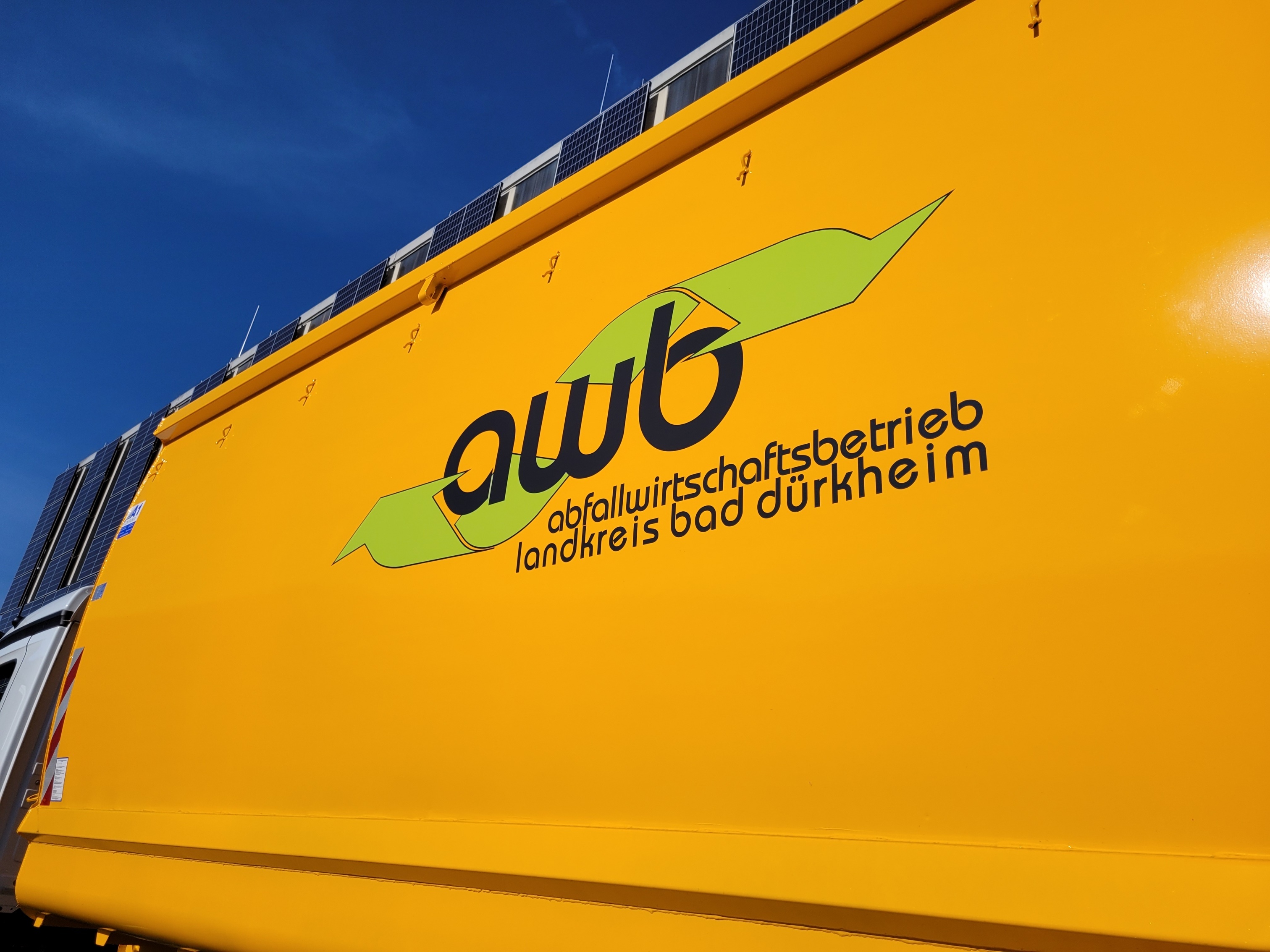 Ein gelber Container mit dem AWB-Logo auf einem LKW. 