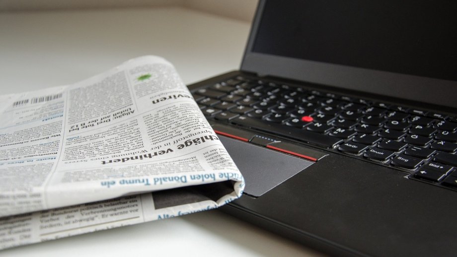 Zeitung liegt auf Laptop