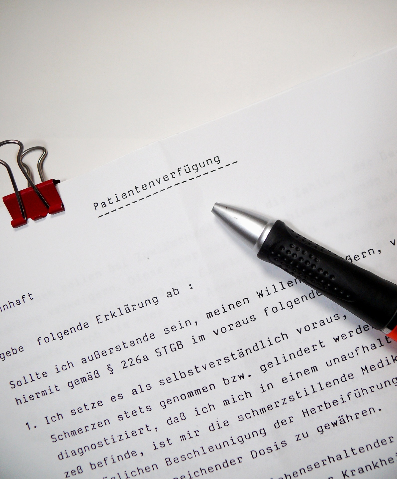 Ein Stift liegt auf einem bedruckten Blatt Papier, auf dem "Patientenverfügung" steht.