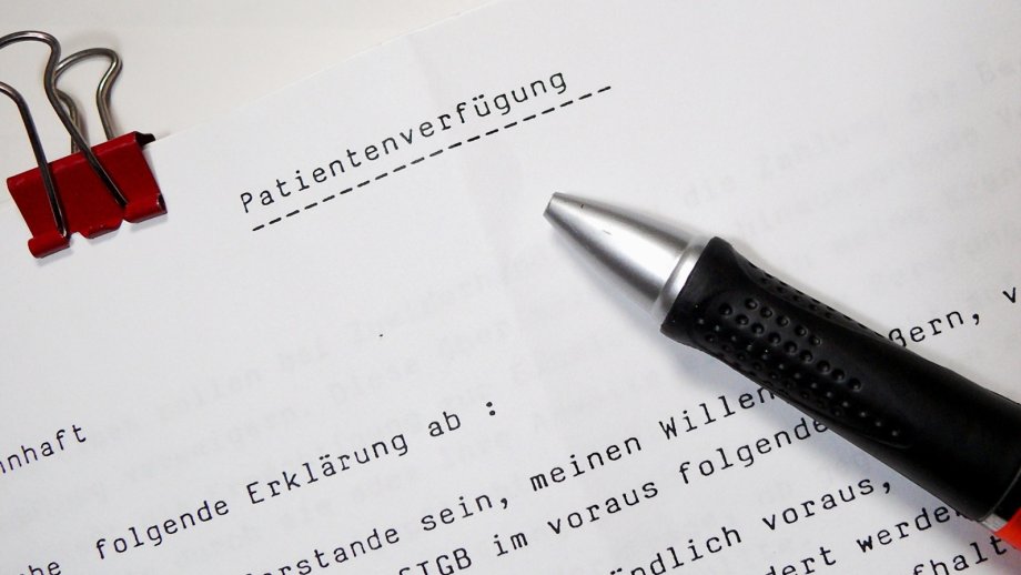 Ein Stift liegt auf einem bedruckten Blatt Papier, auf dem "Patientenverfügung" steht.