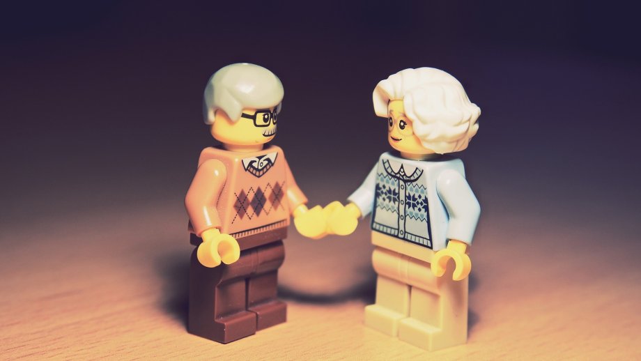 Zwei Lego-Männchen mit grauen Haaren halten Händchen