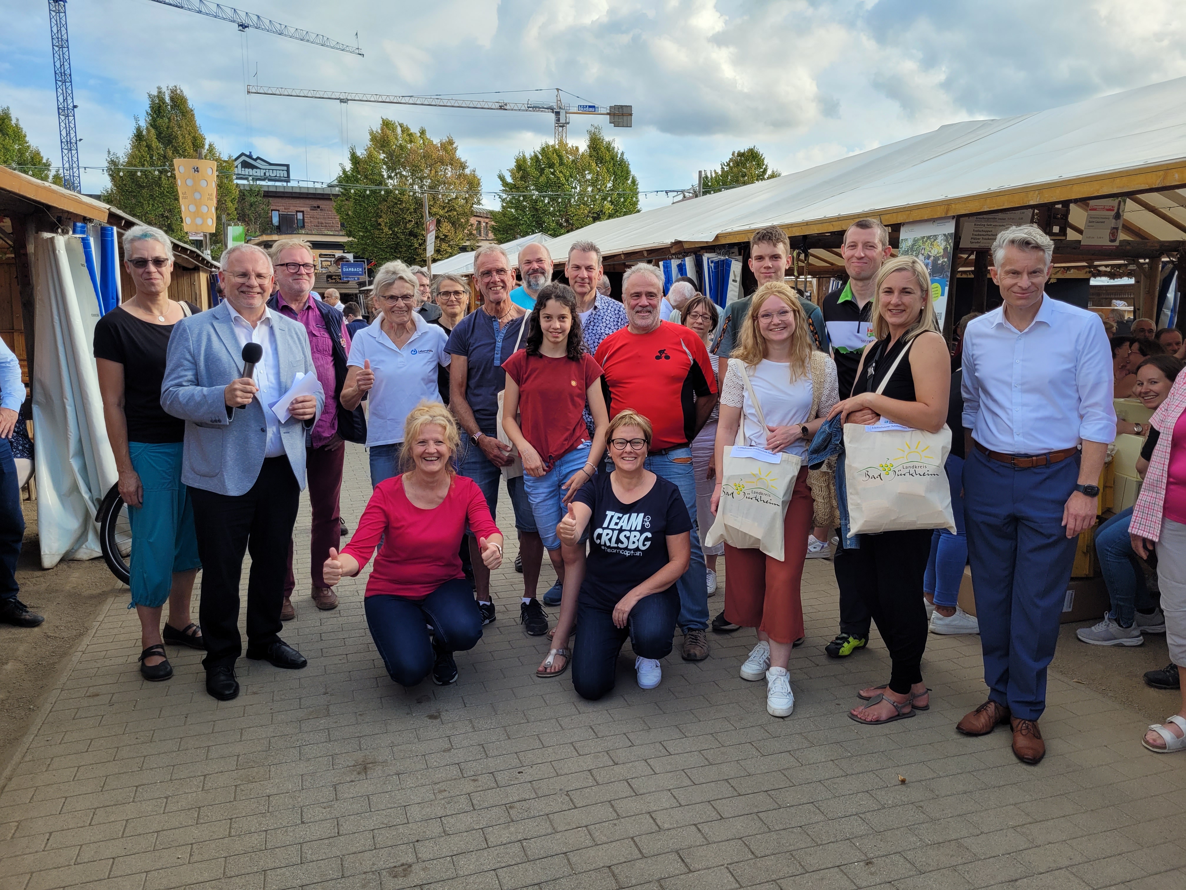 Eine Gruppe Menschen zwischen den Schubkarchständen auf dem Wurstmarkt. 
