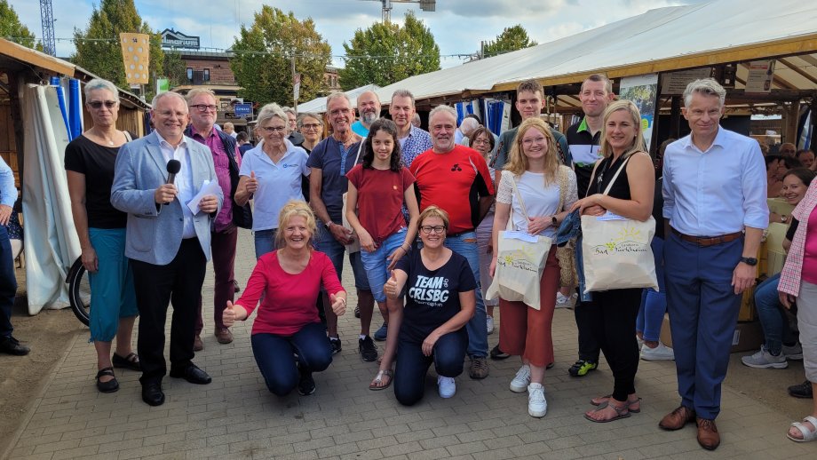 Eine Gruppe Menschen zwischen den Schubkarchständen auf dem Wurstmarkt. 