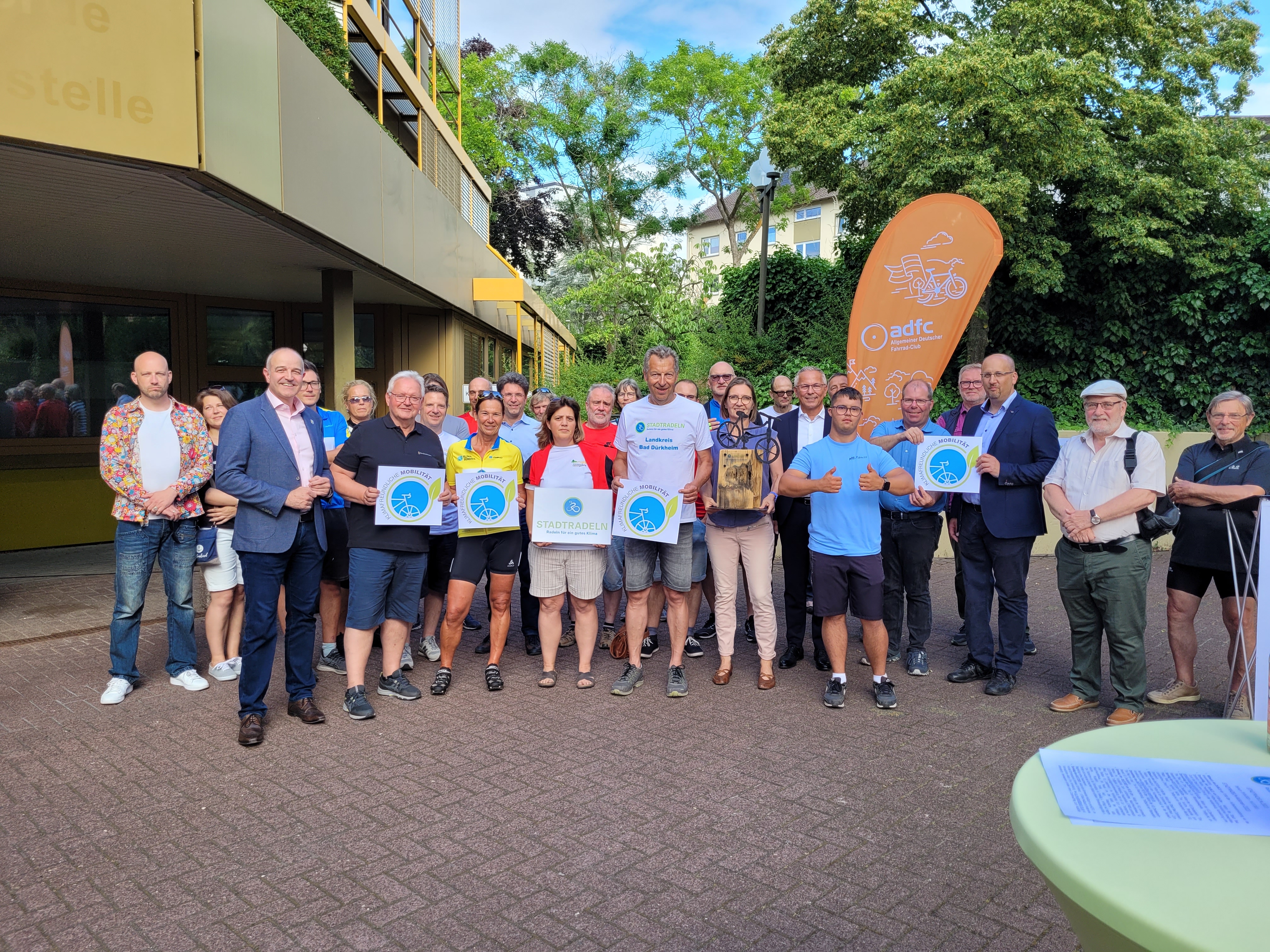 Eine Gruppe Menschen steht vor einem Gebäude der Kreisverwaltung. 