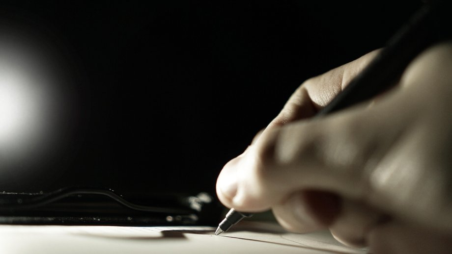 Eine Hand hält einen Stift.