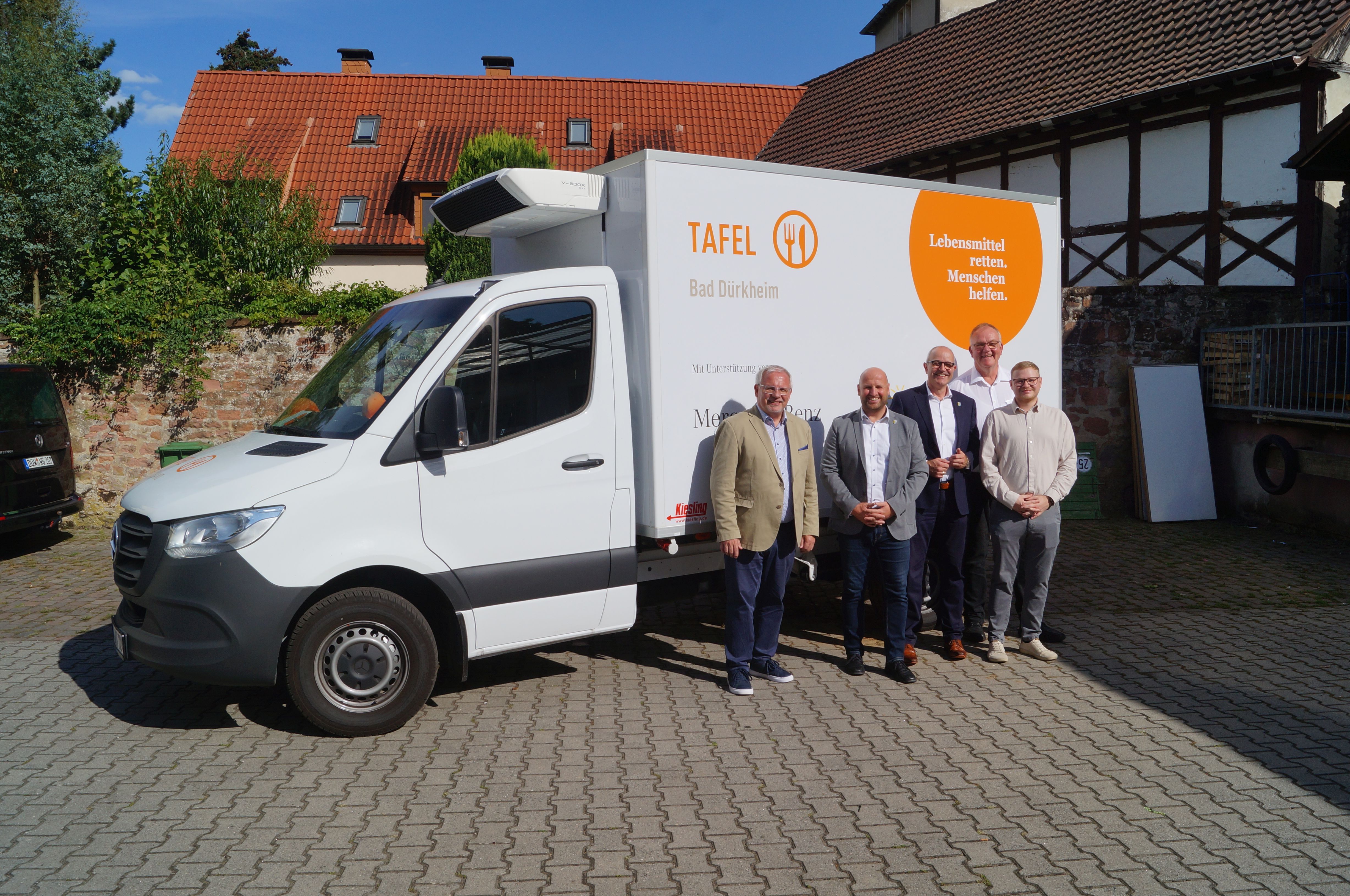 Fünf Männer stehen vor einem weißen Kleinbus mit der Aufschrift "Tafel Bad Dürkheim".