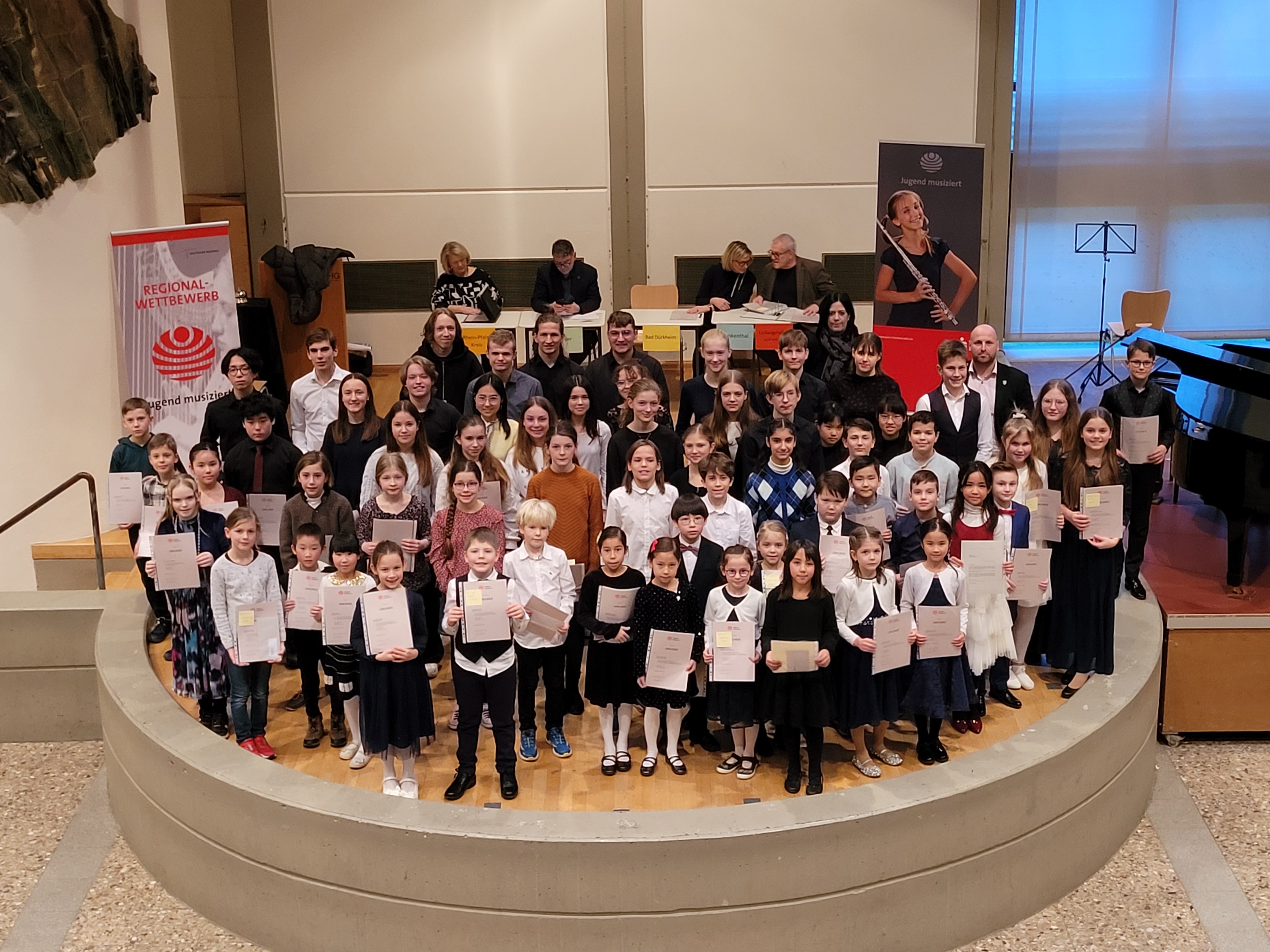 Ein Gruppenbild mit Kindern und Jugendlichen auf einer Bühne.